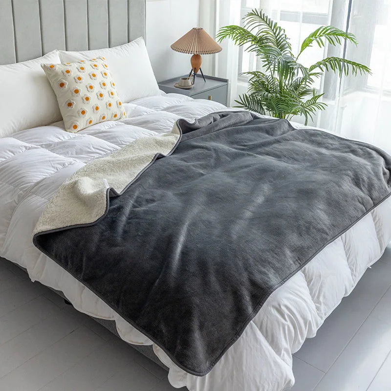 Couverture imperméable gris ardoise sur un lit, côté sherpa visible