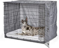 Housse de cage grise installée sur une grande cage métallique, dogue allemand couché à l'intérieur
